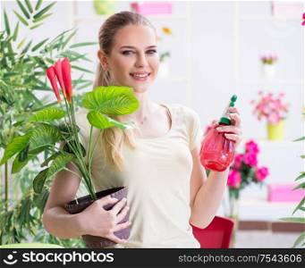 The young woman watering plants in her garden. Young woman watering plants in her garden
