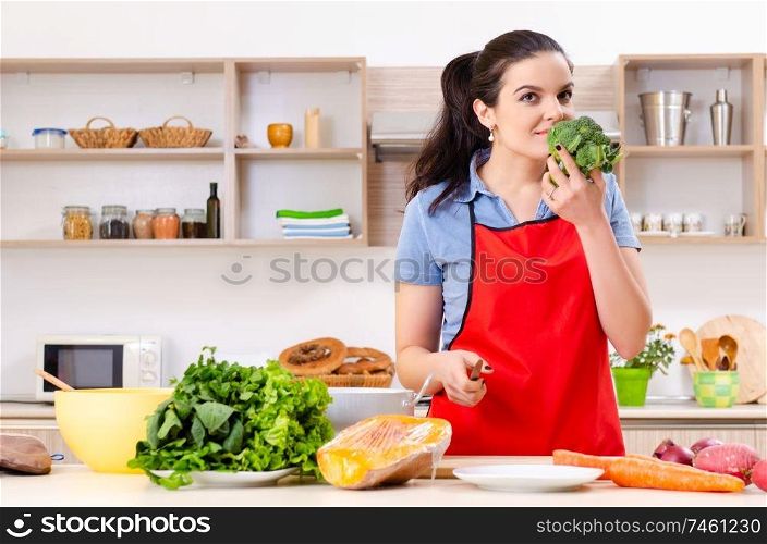 The young woman with vegetables in the kitchen . Young woman with vegetables in the kitchen 