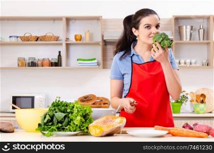 The young woman with vegetables in the kitchen . Young woman with vegetables in the kitchen 