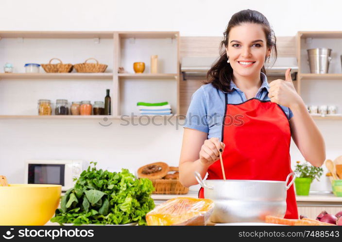 The young woman with vegetables in the kitchen . Young woman with vegetables in the kitchen