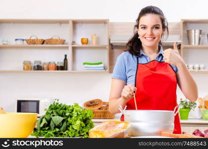 The young woman with vegetables in the kitchen . Young woman with vegetables in the kitchen