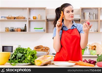 The young woman with vegetables in the kitchen. Young woman with vegetables in the kitchen