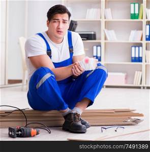 The young worker working on floor laminate tiles. Young worker working on floor laminate tiles