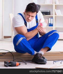 The young worker working on floor laminate tiles. Young worker working on floor laminate tiles