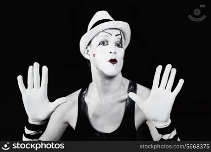 Theater actor in makeup mime clown with a serious face on a blac