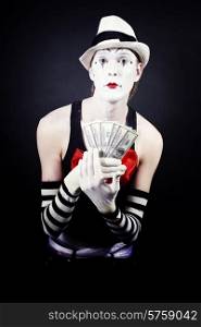 theatrical mime with dollars in their hands on a black background