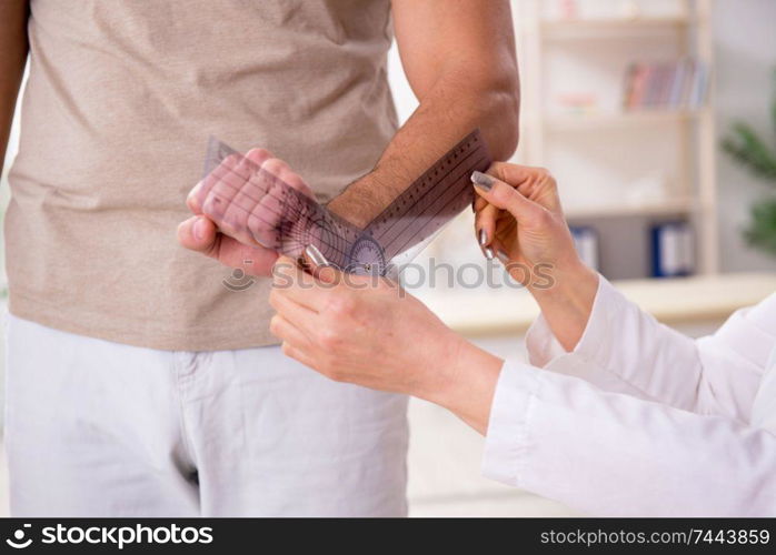 Thefemale doctor checking patient&rsquo;s joint flexibility with goniometer. Female doctor checking patient&rsquo;s joint flexibility with goniometer