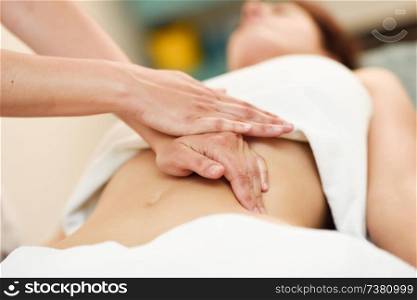 Therapist applying pressure on belly. Woman receiving massage at spa salon. Hands massaging female abdomen. Therapist applying pressure on belly. Hands massaging woman abdomen.