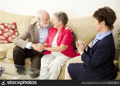Therapist looks on as a senior couple she&rsquo;s been counseling works out their issues.