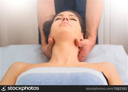 Therapist massaging the neck of woman In the by a professional in studio