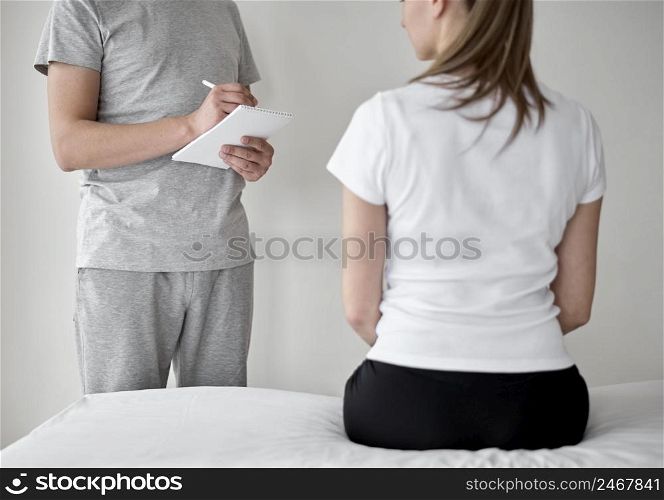 therapist undergoing physical therapy with female patient 5