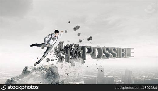 There is nothing impossible. Determined businessman attacking word impossible and breaking letters