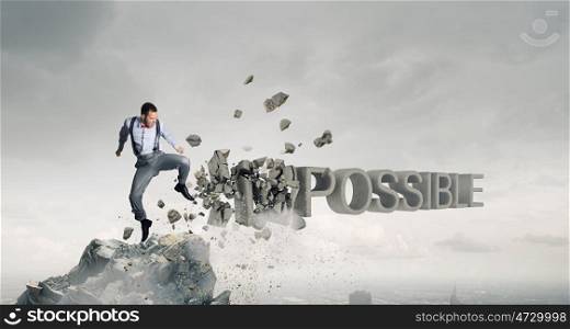 There is nothing impossible. Determined businessman attacking word impossible and breaking letters