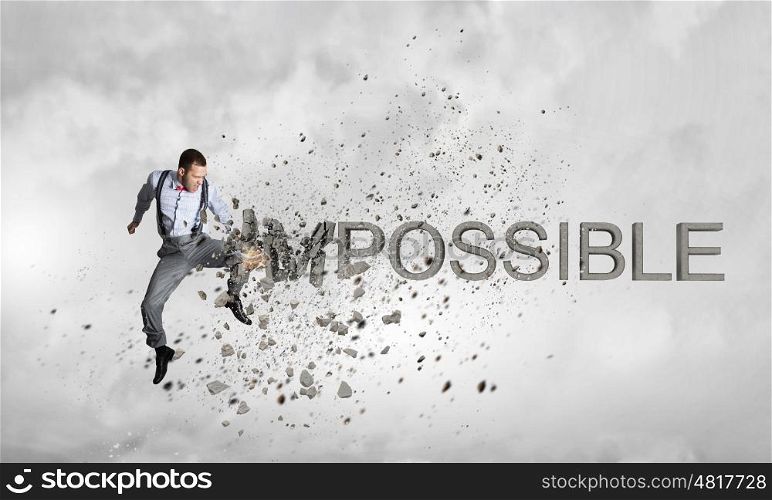 There is nothing impossible. Young emotional man crashing word impossible with hand punch