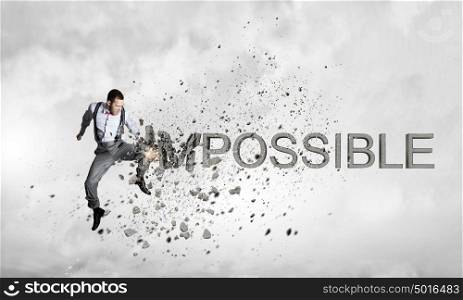 There is nothing impossible. Young emotional man crashing word impossible with hand punch