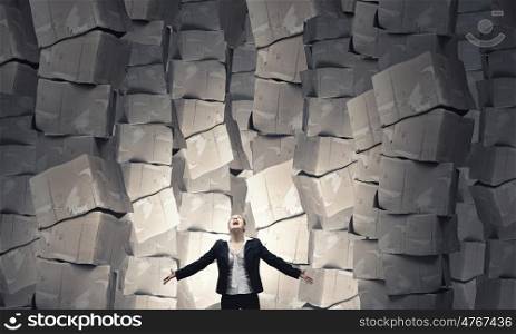 There is so much to do. Businesswoman screaming among pile of carton boxes