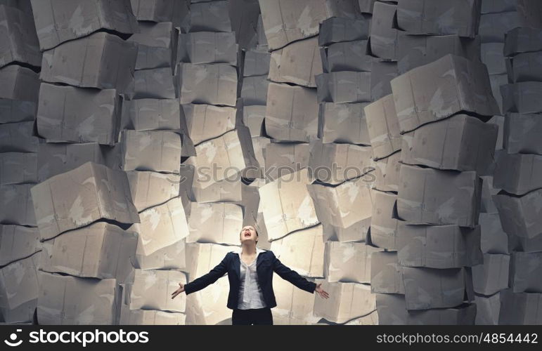 There is so much to do. Businesswoman screaming among pile of carton boxes