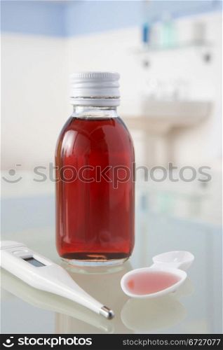 Thermometer and medicine on bathroom shelf