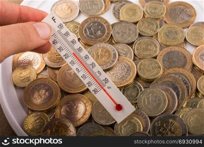 Thermometer in hand beside the Turkish Lira coins