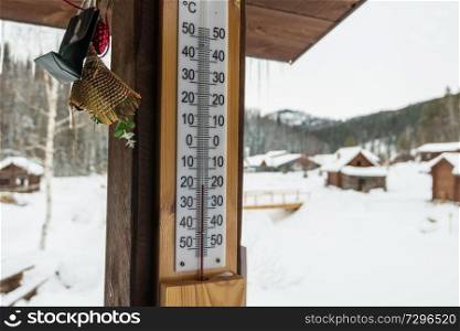 Thermometer on wood house panel in cold winter day. Outdoor thermometer with minus 18 degrees celsius temperature, Altai, Siberia, Russia. Thermometer on wood house panel