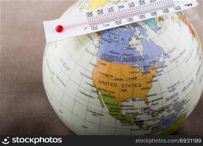 Thermometer placed on a little model globe