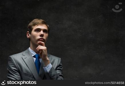 These thoughts in my head. Thoughtful young man in suit on concrete background
