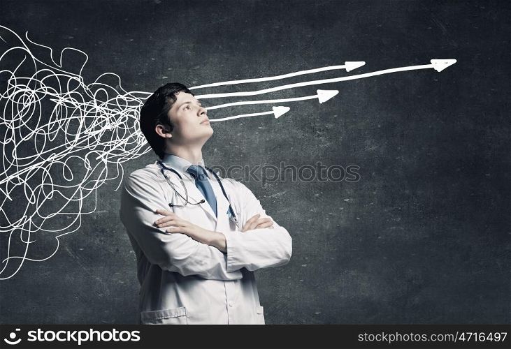 These thoughts in my head. Young man doctor on concrete background and thoughts coming out of his head
