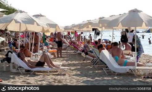 THESSALONIKI, GREECE - AUGUST 23: Crowded summer beach at a tropical resort with beachgoers and holidaymakers relaxing under beach umbrellas on the golden sand on August 23, 2013 in Thessaloniki, Greece
