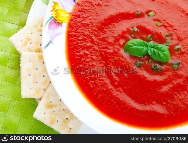 Thick and hearty tomato soup, made from fresh tomatoes and garnished with chives and a sprig of fresh basil. Served with lightly salted crackers.