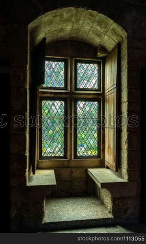 Thick stone walls of the palace of the Dukes of Braganza wiht window seat in Guimaraes in northern Portugal. Window seat inside the palace of the Dukes of Braganza