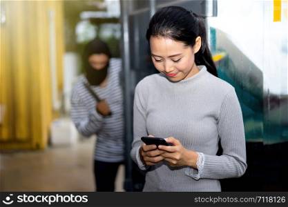Thief looking women while her playing smart phone. criminal and robbery for women concept.