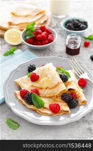Thin crepes with fresh berries and lemon zest. Pancakes with raspberry and blackberry.