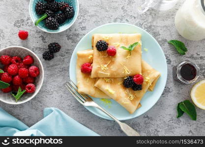 Thin crepes with fresh berries and lemon zest. Pancakes with raspberry and blackberry.