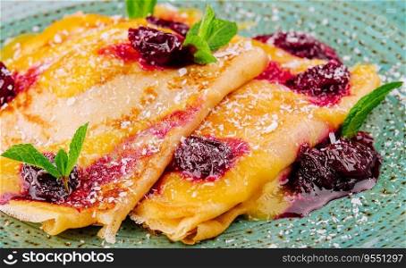 thin pancake with cherry syrup and berries