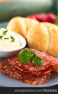 Thin salami slices garnished with watercress leaf with cream cheese and buns on plate (Selective Focus, Focus on the front of the watercress leaves). Salami Slices
