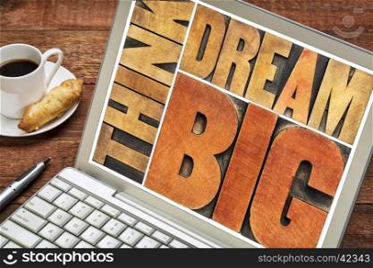 think and dream big motivational phrase - word abstract in letterpress wood type printing blocks on a laptop screen with coffee