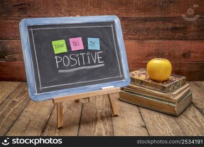 think, do, be positive - positivity concept, color sticky notes, white chalk and handwriting on a vintage slate blackboard in a retro classroom