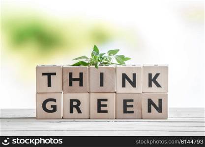 Think green sign with a plant on a wooden table