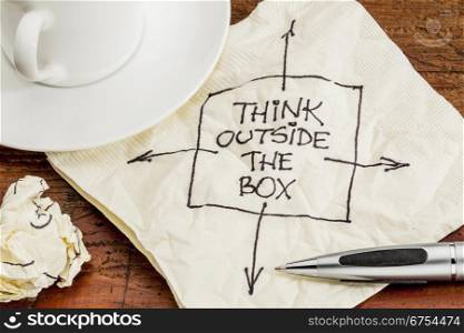 think outside the box - black pen drawing on a cocktail napkin with a coffee cup on a table