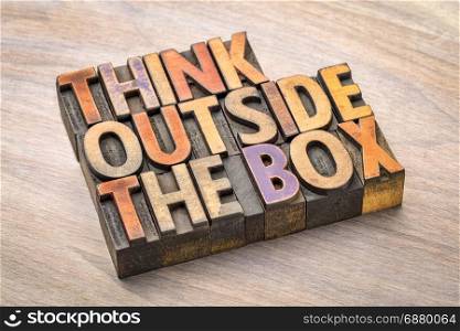 think outside the box concept- motivational phrase in vintage letterpress wood type against grained wood