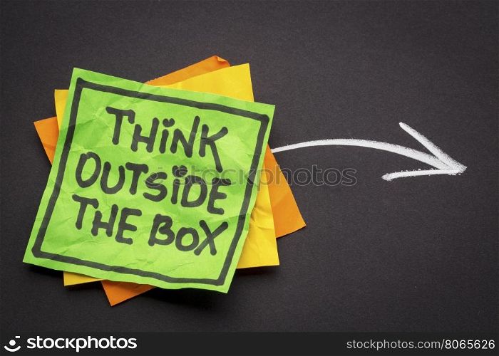 think outside the box - reminder note against black paper with white chalk drawing