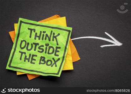 think outside the box - reminder note against black paper with white chalk drawing