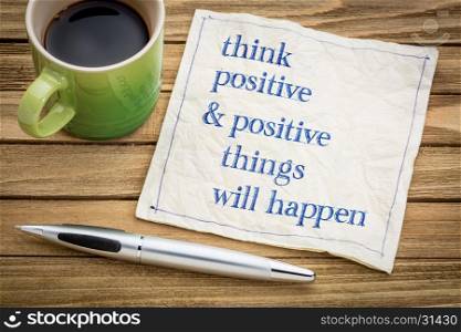 Think positive and positive things will happen - law of attraction concept - handwriting on a napkin with a cup of coffee