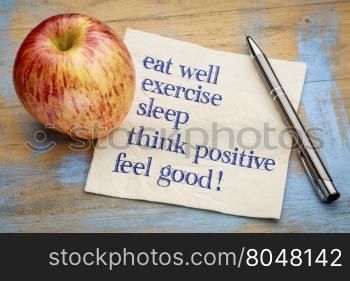 think positive , exercise, eat well, sleep - concept of feeling good - handwriting on a napkin with an apple