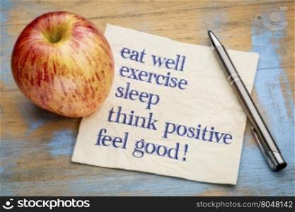 think positive , exercise, eat well, sleep - concept of feeling good - handwriting on a napkin with an apple