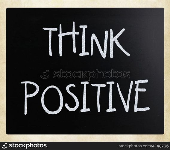 ""Think positive" handwritten with white chalk on a blackboard"