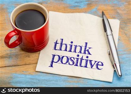 think positive - mindset concept on a napkin with a cup of coffee against grunge wood