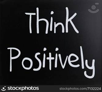 ""Think Positively" handwritten with white chalk on a blackboard"
