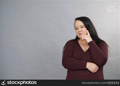 Thinking adult woman, plus size female gesturing with hands seeking for solution, having contemplating face expression.. Thinking adult woman