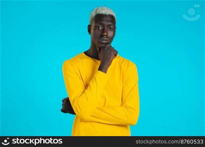 Thinking african man looking to camera on blue background. Pensive face expressions. Handsome male black model. Thinking african man looking to camera on blue background. Pensive face expressions. Handsome male black model.